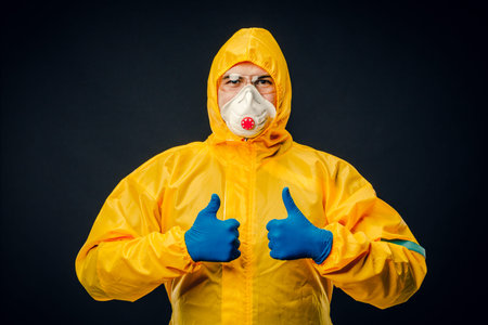 A man in a protective suit on a black background. Protection against virus outbreaks.