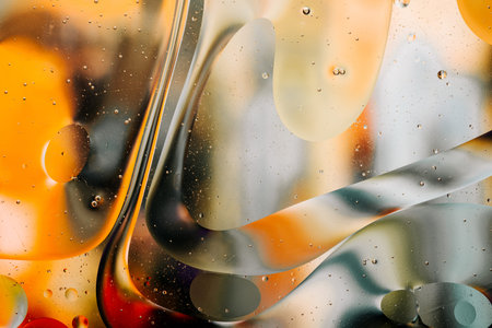 Close-up of the movement of oil droplets on the water surface. Colorful abstract macro background of...