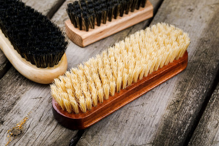 Accessories for the care and cleaning of shoes on a wooden table.