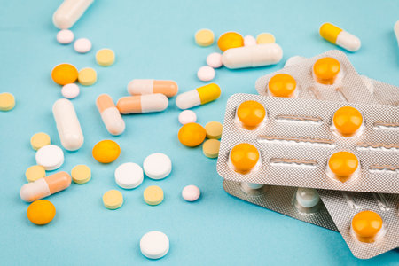 A bunch of pills on a blue background. The concept of healthcare.