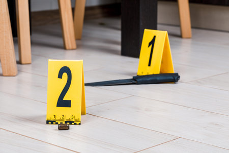 A shell casing or bullet at a crime scene with evidence markers