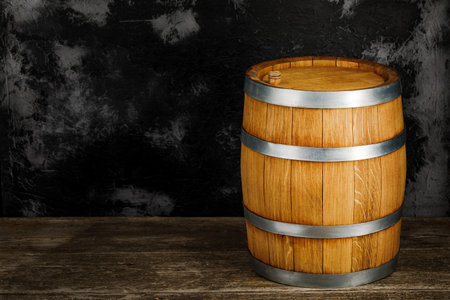A beautiful wooden barrel and a worn oak wood table set against a dark wall pattern for the design.