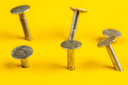 Metal nails close-up, lots of nails on a yellow background