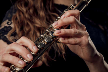 Close-up of the hands of a woman playing the flute. Musical conceptの写真素材