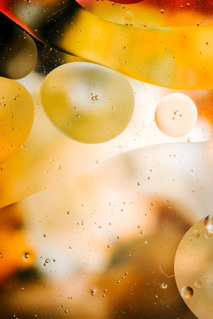 Close-up of the movement of oil droplets on the water surface. Colorful abstract macro background of...