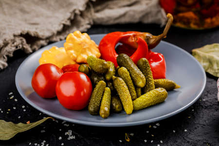 A bowl of pickled vegetables on a dark background. Picklesの写真素材