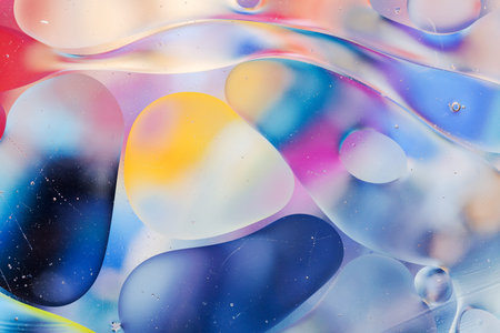 Close-up of the movement of oil droplets on the water surface. Colorful abstract macro background of...
