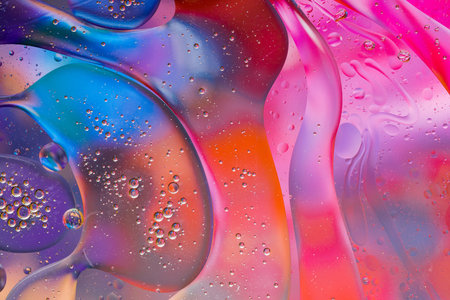 Close-up of the movement of oil droplets on the water surface. Colorful abstract macro background of oil drops on the water surfaceの写真素材
