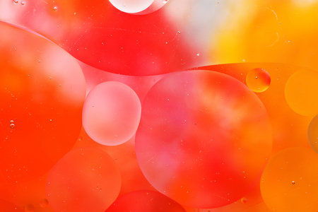 Close-up of the movement of oil droplets on the water surface. Colorful abstract macro background of...