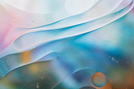 Close-up of the movement of oil droplets on the water surface. Colorful abstract macro background of...