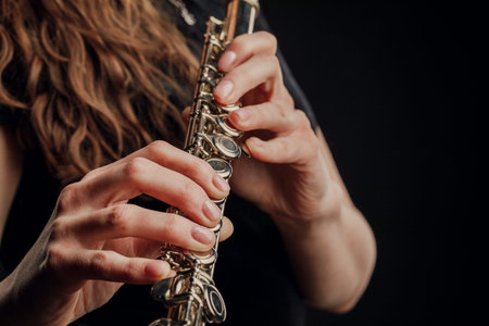 Close-up of the hands of a woman playing the flute. Musical concept