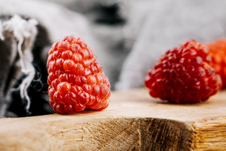 Fresh juicy raspberries in a wooden table. Summer still life with raspberries. A place to copy.