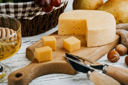 Cheese dish with organic cheeses, fruits, nuts on a wooden background. Delicious cheese snackの写真素材