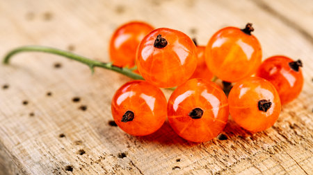 Ripe red currant berries in a bowl. Fresh red currants on a dark rustic wooden table. Background...