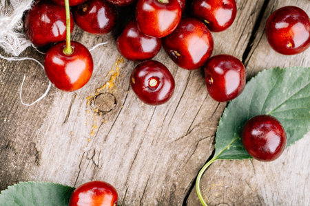 Ripe red cherries on a wooden table.