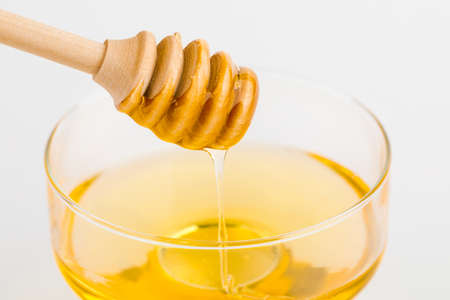 Honey ladle. Honey tidbit in a glass jar.の写真素材