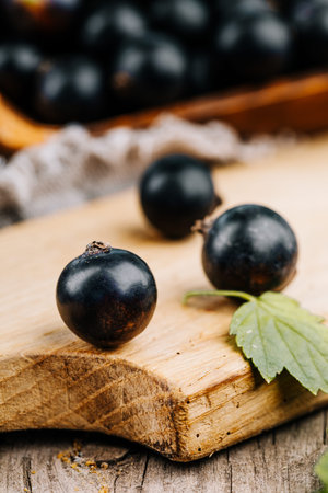 Fresh black currant. A handful of berries on a wooden table.