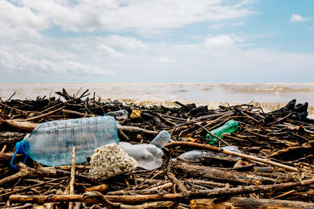 The sea coast after the storm. Plastic and wood waste on the beach pollute the environment. An environmental problem.の写真素材