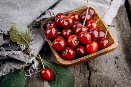 Ripe red cherries on a wooden table.の写真素材