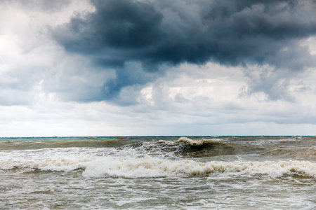 Storm clouds over the sea. Dramatic sky and giant waves.
