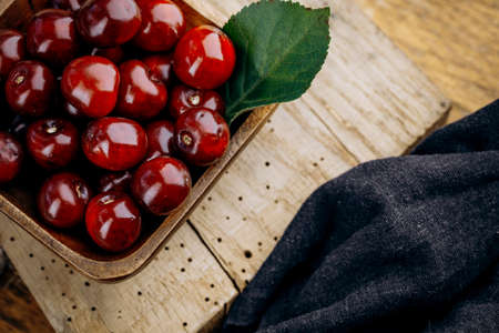 Ripe red cherries on a wooden table.の写真素材