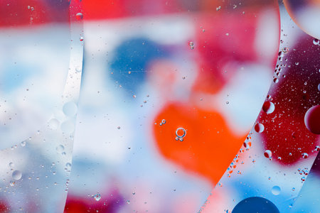 Close-up of the movement of oil droplets on the water surface. Colorful abstract macro background of...