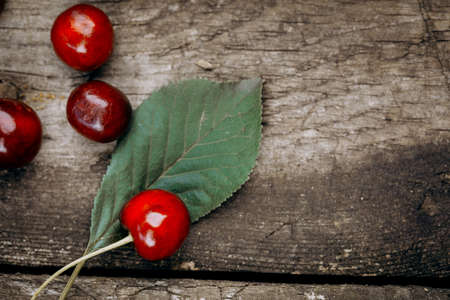 Ripe red cherries on a wooden table.の写真素材