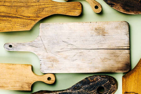 Top view of a set of various handmade wooden cutting boards on a green background.の写真素材