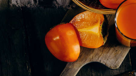 A group of ripe orange persimmon fruits.Persimmon fruits on a wooden board, rustic background.の写真素材