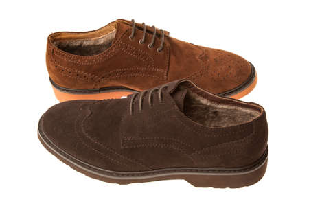 pair of shoes with elements of cowboy boots, fur and shoelaces different brown color isolated on white backgroundの写真素材