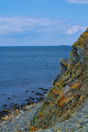 rock cliff edge in front of sea and blue sky.の写真素材