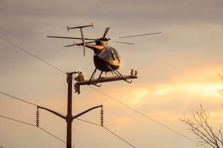 Helicopter hovering in flight with man sitting on the outside fixing power lines repairing wires