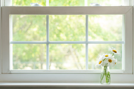 Daisy Bouquet In Small Clear Glass Vase On White Windowsill