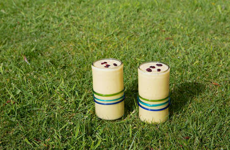 Two healthy drinks, yellow smoothies with red cranberries on topの写真素材