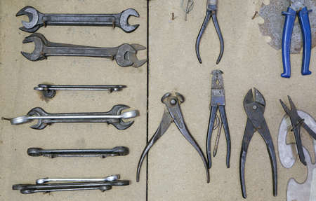Various vintage old metal tools on wooden board in workshopの写真素材
