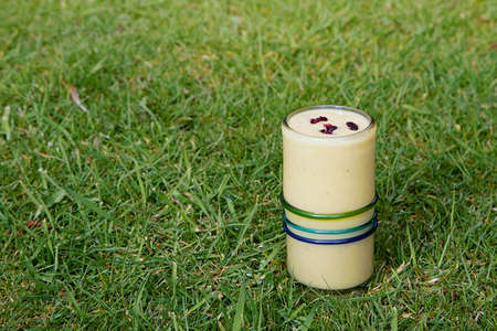 Healthy drink, yellow smoothie with red cranberries on topの写真素材