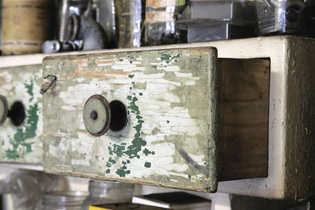 Vintage old wooden drawer in cupboard in workshop. Closeup, half open. Green lacquerの写真素材