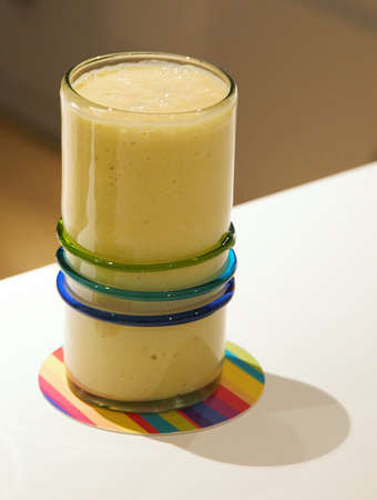 Healthy drink mango yellow smoothie on white tableの写真素材