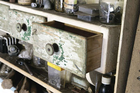 Vintage old wooden drawer in cupboard in workshop. half open. Green lacquerの写真素材