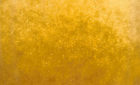 Bubbles floating in the liquid yellow drink, abstract image.の写真素材
