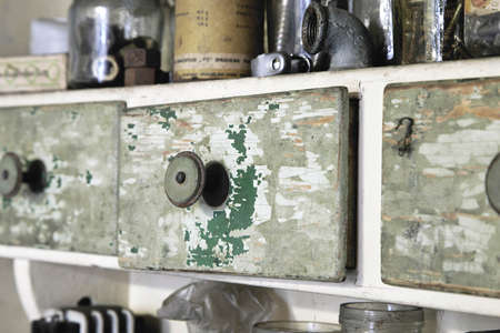 Vintage old wooden drawer in cupboard in workshop. Closeup, closed. Green lacquerの写真素材