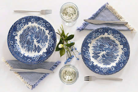 Empty plates and wine glasses, romantic dinner for two. Homey atmosphere clean white table. Top viewの写真素材