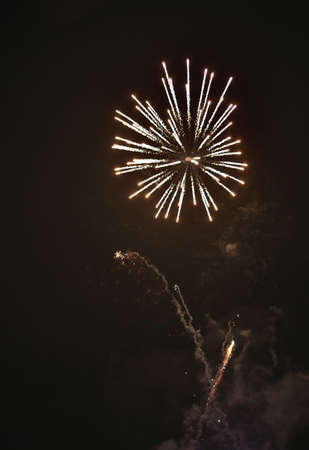 Shiny natural fireworks on dark black sky background with a little smokeの写真素材