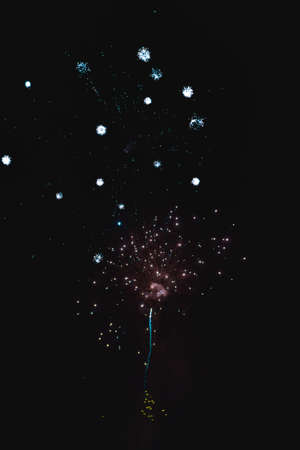 Shiny natural fireworks on dark black sky background with a little smokeの写真素材