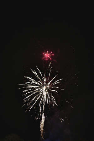 Shiny natural fireworks on dark black sky background with a little smokeの写真素材