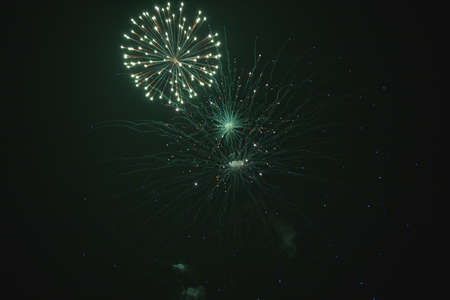 Shiny natural fireworks on dark sky background with little smoke
