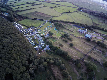 Aerial view, Drone panorama golden hour sunset over Barcdy touring caravan and camping tent park in Walesの写真素材