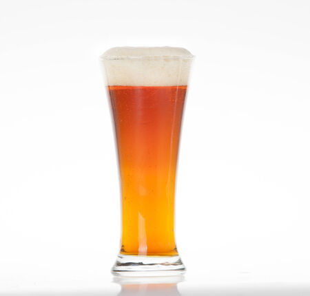 Amber ale beer in a glass on a white backgroundの写真素材