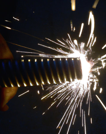 Close up of black spiral sparkler producing multiple sparks, created using generative ai technology. Party and celebration concept, digitally generated image.の素材