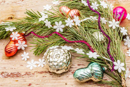 Vintage Christmas tree toys. New Year holiday concept. Evergreen pine branch, old wooden boards background, top view, close upの写真素材